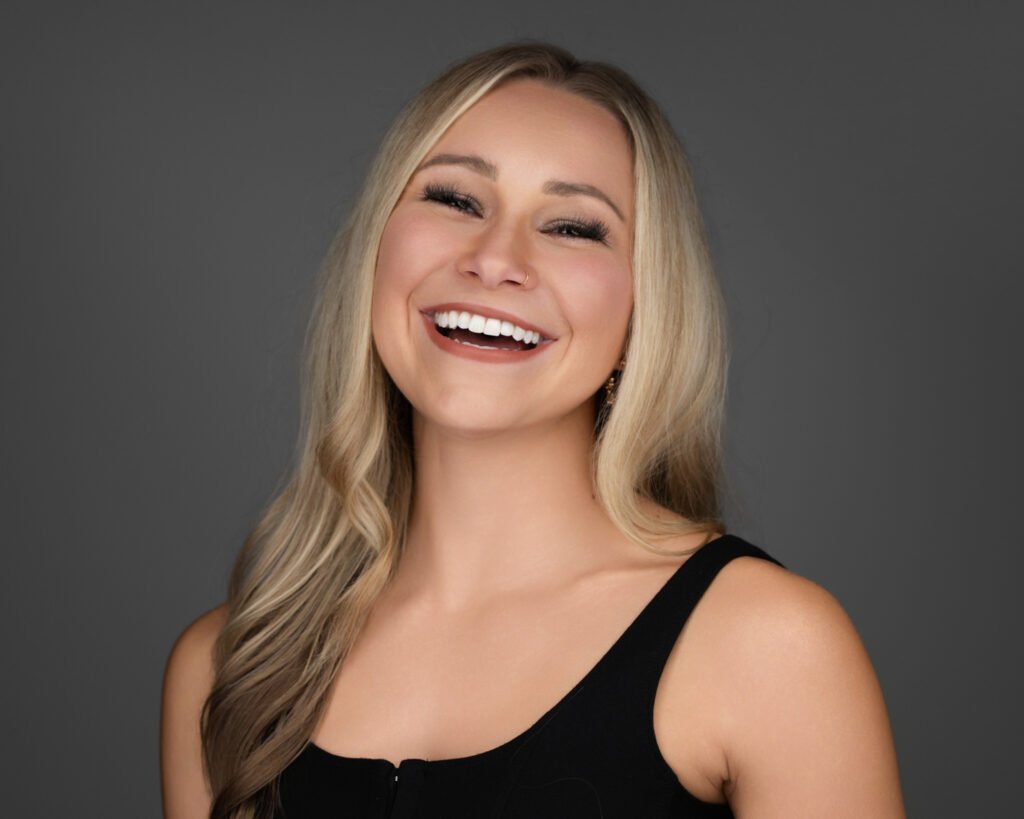 A professional headshot with a beautiful woman laughing