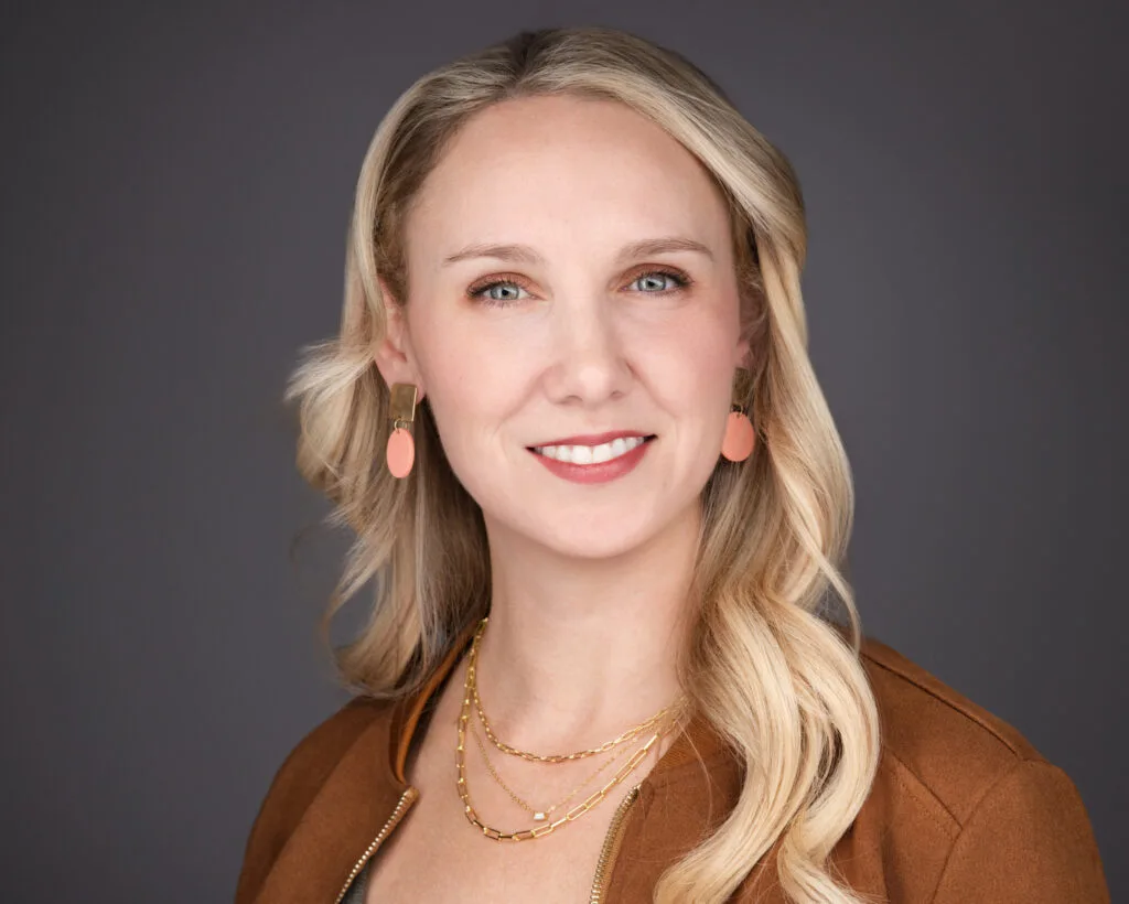 LinkedIn headshot with neutral grey background for business profile use.